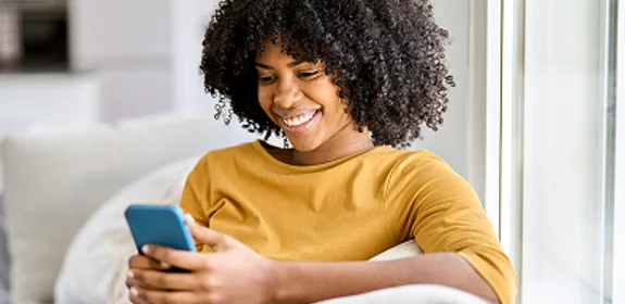 Vrouw kijkt op haar mobiel naar de website van Wizzer. En is benieuwd wat Wizzer precies inhoudt.